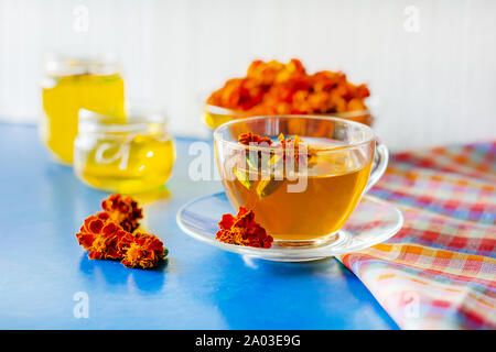 Eine Tasse Tee aus den Blüten der Calendula und Chernobrivtsov. Verarbeitung von getrockneten Blumen Tagetes. Stockfoto