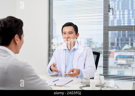 Asiatische Arzt berät junge Patienten Stockfoto