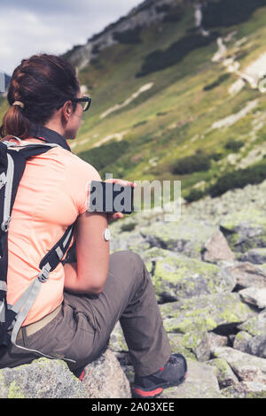 Das aktive Leben der Diabetiker, Frau wandern und Kontrolle der Blutzuckerspiegel über einen Remote Sensor und Handy, neue Technologie sensor Checkup Blutzuckerspiegel Stockfoto