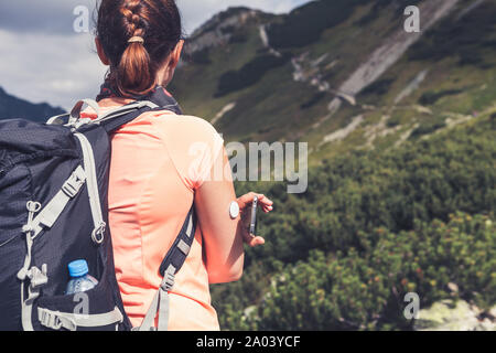 Das aktive Leben der Diabetiker, Frau wandern und Kontrolle der Blutzuckerspiegel über einen Remote Sensor und Handy, neue Technologie sensor Checkup Blutzuckerspiegel Stockfoto