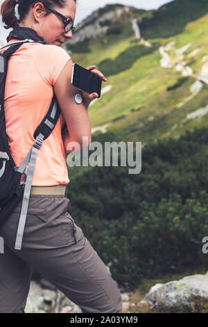 Das aktive Leben der Diabetiker, Frau wandern und Kontrolle der Blutzuckerspiegel mit einer Fernbedienung neue Technologie sensor und Handy ohne Blut Stockfoto