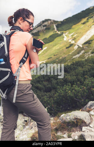 Das aktive Leben der Diabetiker, Frau wandern und Kontrolle der Blutzuckerspiegel mit einer neuen Technologie remote Sensor und Handy ohne Blut Stockfoto