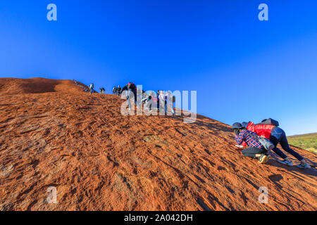 Uluru, Northern Territory, Australien - 23.August 2019: viele Menschen Klettern am Ayers Rock. Climbing Uluru heilig ist Anangu Leute, die traditionelle Stockfoto