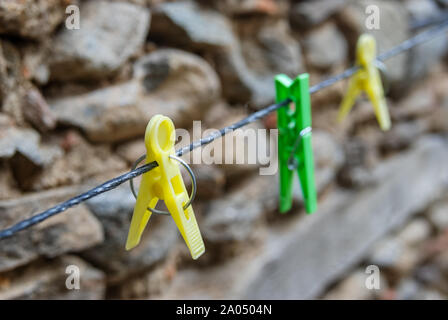 Diagonale bunten Kunststoff leer Wäscheklammern hängen an String in einen Hinterhof. Selektive konzentrieren. Stockfoto