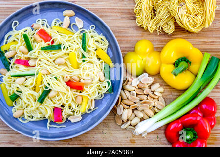 Nudel und Erdnuß-Salat mit gerösteten Erdnüssen, Feder Onionsn Rote und gelbe Paprika Stockfoto