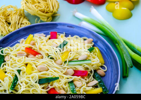 Nudel und Erdnuß-Salat mit gerösteten Erdnüssen, Feder Onionsn Rote und gelbe Paprika Stockfoto