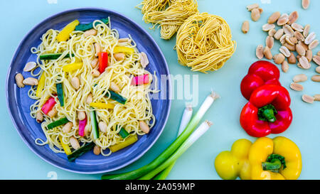 Nudel und Erdnuß-Salat mit gerösteten Erdnüssen, Feder Onionsn Rote und gelbe Paprika Stockfoto