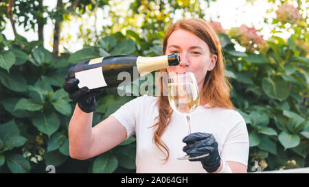 Weibliche Barkeeper gießen Champagner in Glas, close-up im Freien. Konzept über Trinken, Alkohol und der Service im Restaurant, Catering Stockfoto