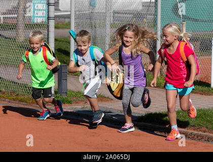 Kinder mit Taschen und rackets auf Tennisplatz Stockfoto