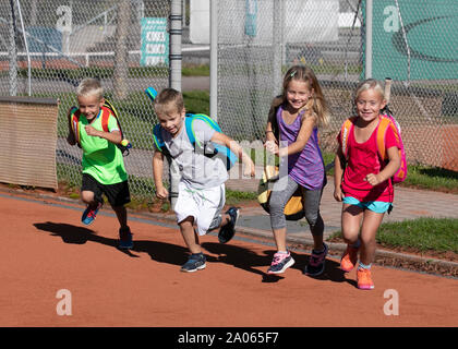 Kinder mit Taschen und rackets auf Tennisplatz Stockfoto