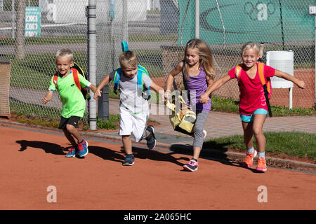 Kinder mit Taschen und rackets auf Tennisplatz Stockfoto