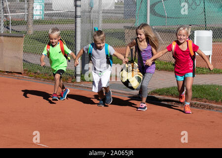 Kinder mit Taschen und rackets auf Tennisplatz Stockfoto