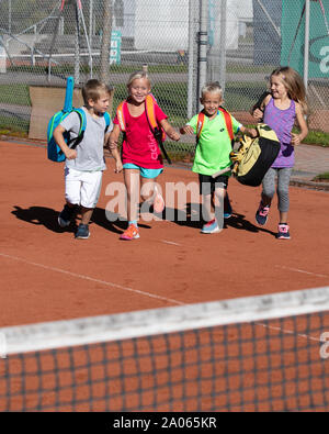 Kinder mit Taschen und rackets auf Tennisplatz Stockfoto