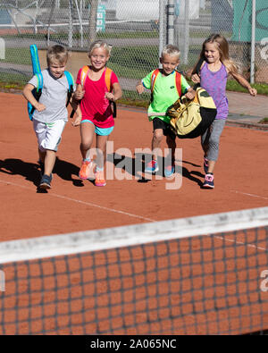 Kinder mit Taschen und rackets auf Tennisplatz Stockfoto