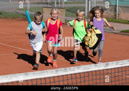 Kinder mit Taschen und rackets auf Tennisplatz Stockfoto