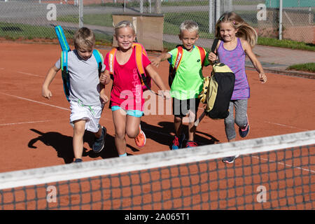 Kinder mit Taschen und rackets auf Tennisplatz Stockfoto