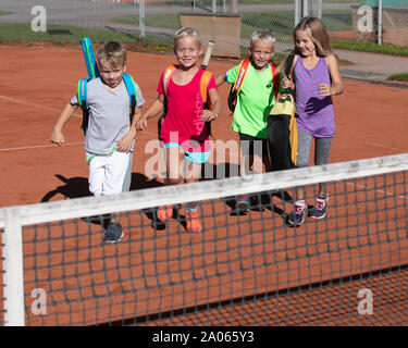 Kinder mit Taschen und rackets auf Tennisplatz Stockfoto