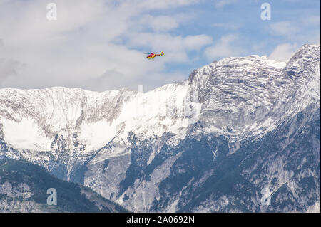 Rettungshubschrauber vor einem Gebirge, Stockfoto