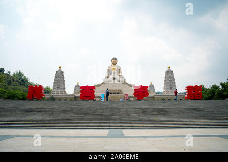 Touristen zu Fuß die Treppe hinauf auf die große Buddha Statue des Fo Guang Shan Buddha Museum mit dem Museum Name in großen chinesischen Buchstaben geschrieben Stockfoto