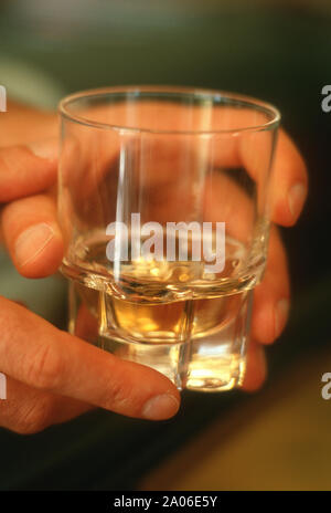 Des Menschen Hand mit einem Glas Schnaps, weiblichen Alkoholismus Stockfoto