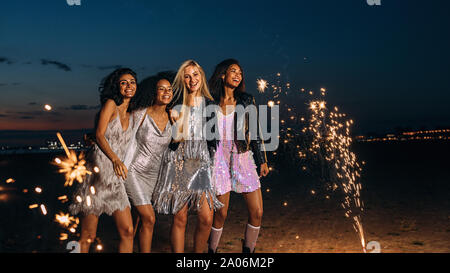 Vier Freunde gekleidet für Party Spaß draußen in der Nacht Stockfoto