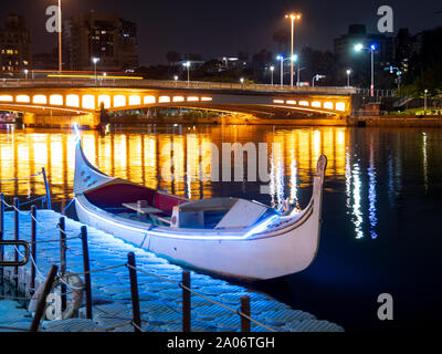 Kaohsiung, Taiwan: im italienischen Stil Gondel (Boot) am Pier auf Love River nachts geparkt, bunte Lichter der Brücke im Wasser widerspiegelt Stockfoto