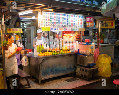 Taipei, Taiwan: taiwanische Mann an seiner Street Food stall arbeiten Verkauf von frischen Früchten und Säften auf lokaler Nachtmarkt in Taipei Stockfoto