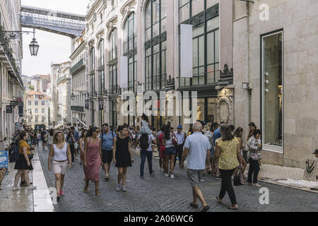 Lissabon, Portugal - August 2019: Touristen wandern in der Fußgängerzone der Rua do Carmo in Baixa in der Innenstadt. Auf dem Hintergrund der Struktur der Stockfoto