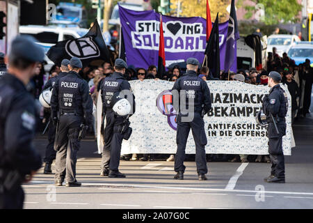 Essen, Deutschland. 19 Sep, 2019. Polizisten begleiten ein Protestzug durch die antifaschistischen Demonstranten, die ein Spruchband mit der Aufschrift "Kampf Nazimacker, Antifaschismus in die Offensive". Sie sind an einer Demonstration gegen die so genannte wöchentliche 'Walk' der rechten Gruppe teeler Jungs'. Credit: Marcel Kusch/dpa/Alamy leben Nachrichten Stockfoto