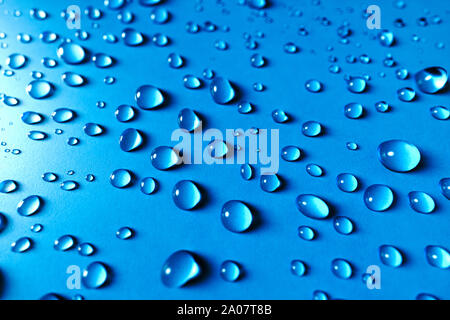 Glitzernde perlen Wassertropfen auf einem blauen Hintergrund in eine zufällige Textur und Muster für ein Hintergrundbild Stockfoto