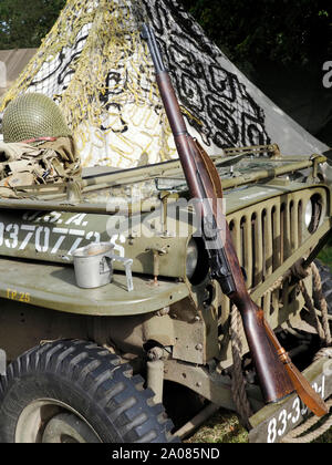 Ein M1 Garand Gewehr, standard U | S Army in WW2 lehnt sich gegen ein Willys Jeep mit Helm und andere Kit auf der Motorhaube. Stockfoto