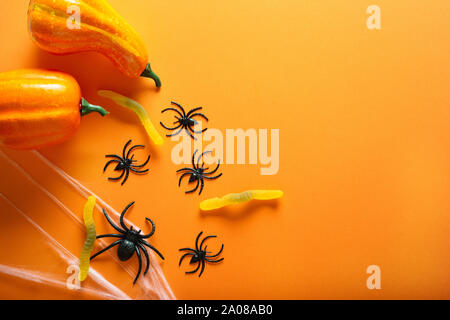 Halloween Hintergrund mit Kürbissen, candy Wurm, Spinnennetz und Spinnen als Symbole von Halloween auf dem orangen Hintergrund. Happy Halloween Konzept. Top Stockfoto