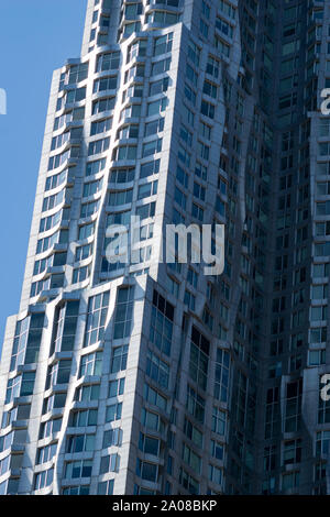 Von der Morgensonne angestrahlte Detailansicht vom Frank Gehry-Hochhaus in NEW YORK in Manhattan. Beeindruckende moderne Architektur silber glänzend mit vi Stockfoto