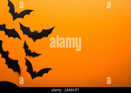 Halloween und Dekoration - schwarzes Papier Fledermäuse über orange Hintergrund fliegen. Kopieren Sie Platz. Stockfoto