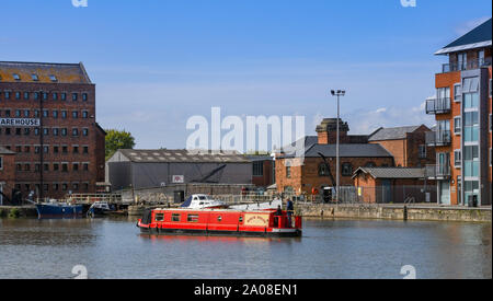 GLOUCESTER QUAYS, ENGLAND - September 2019: Schmale Boot segeln über die Docks im regeneriert Gloucester Quays. Stockfoto