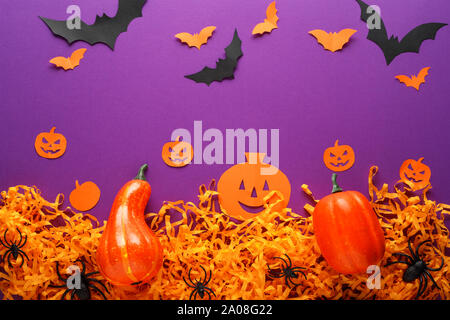 Halloween Dekorationen mit Kürbissen, Spinnen, Fledermäusen, Papier Jack O'Lantern auf dem violetten Hintergrund. Happy Halloween Konzept. Stockfoto