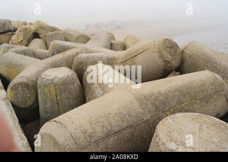 Tetrapoden-Wellenbrecher in Meeresgewässern mit Betontetrapoden zum Schutz von Küstenstrukturen vor Sturmwellen Stockfoto