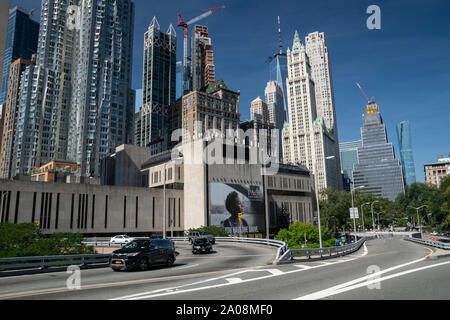 Im Vordergrund sieht man sterben Straße, sterben Über die Brooklyn Bridge führt. Dahinter befindet sich die Pace Universität mit Werbeplakat. Das ganze vor de Stockfoto