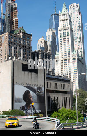 Im Vordergrund sieht man sterben Straße, sterben Über die Brooklyn Bridge führt. Dahinter befindet sich die Pace Universität mit Werbeplakat. Das ganze vor de Stockfoto