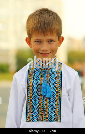 Outdoor Portrait einer Glücklich lächelnde Junge in vyshyvanka - traditionelle ethnische ukrainischen Kleidung Stockfoto