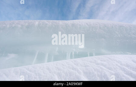 Weißer Schnee close-up. Schneeverwehungen und Eiszapfen close-up. Gefrorener Schnee in einem Haufen. Winter Hintergrund. Stockfoto