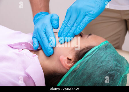 Eine Ansicht von oben Physiotherapeuten durchführen Kiefer Massage Stockfoto