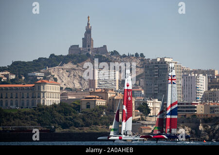 Schließen segeln zwischen Japan SailGP Team mit Skipper von Nathan Outteridge und Großbritannien SailGP Team helmed von Dylan Fletcher, wie Sie fahren vorbei an der Notre-Dame de la Garde während einer Praxis Rennen vor der endgültigen SailGP Ereignis der Saison 1 in Marseille, Frankreich. Stockfoto