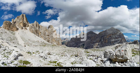 Panorama Blick auf die wilde Berglandschaft mit felsigen Gipfeln und einen Wanderweg, Markierung und den Pfad in den Vordergrund in den italienischen Dolomiten Stockfoto
