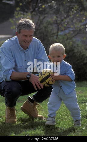 Vater und Sohn Ball spielen im Garten Stockfoto
