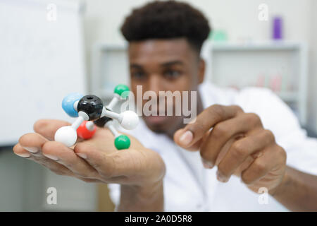 Junge Mann arbeitet an einem Modell des Moleküls Stockfoto