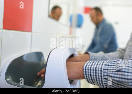 Junger Mann trocknet seine Hände Stockfoto