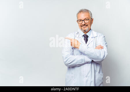 Fröhliche reife Arzt posing und lächelnd an Kamera, Gesundheitswesen und Medizin. Stockfoto