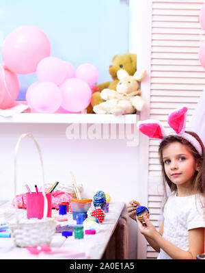 Tochter malen handgefertigte Ei bei Party Luftballons. Ostern, Kind in rosa Hasenohren. Happy Family feiern Frühling Urlaub, Liebe. Frohe Ostern mit kleinen Stockfoto