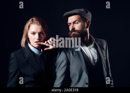 Paar Detektive oder Forscher, private Ermittler. Der Mann und die Frau in der retro Anzug und Hut auf schwarzen Hintergrund. Privatdetektiv Konzept. Cou Stockfoto